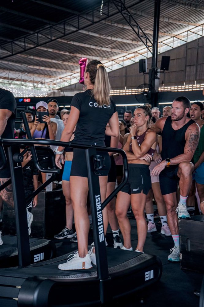 Hybrid athletes gathered around a coach during a gym event
